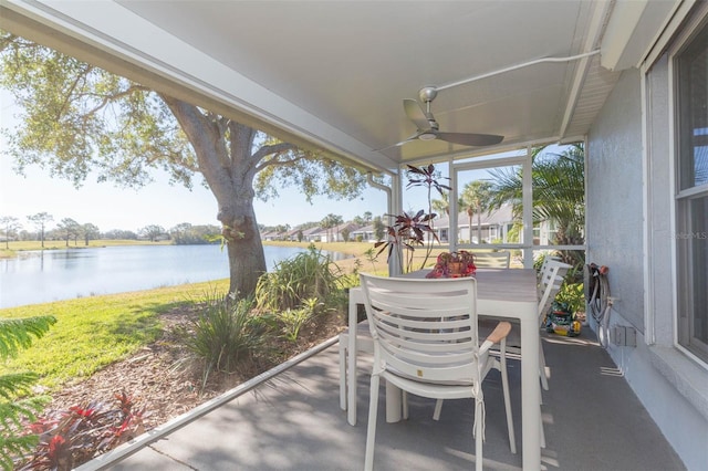 sunroom with a water view and ceiling fan