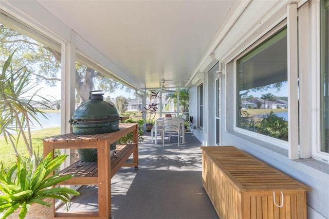 sunroom featuring a water view