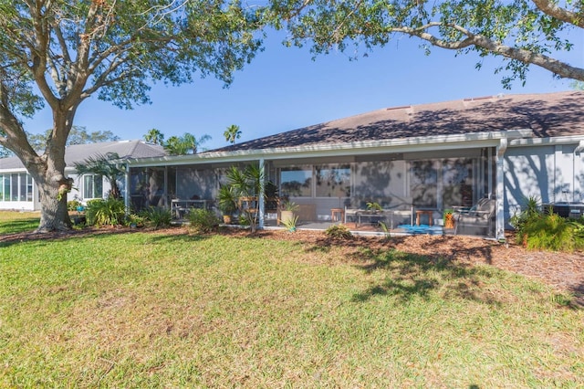 back of property featuring a lawn, a sunroom, and a patio