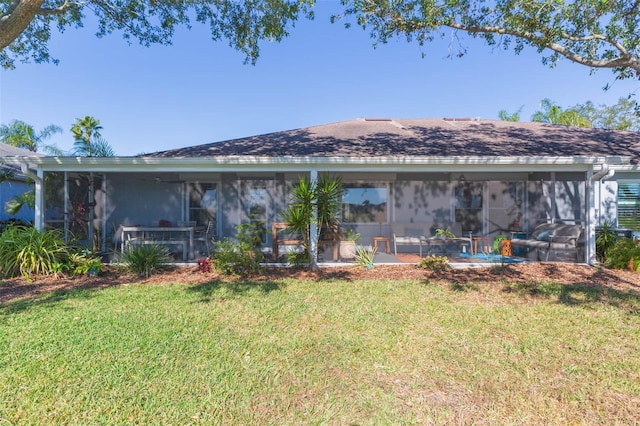 rear view of house featuring a lawn