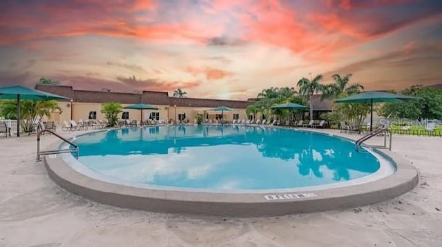 pool at dusk with a patio