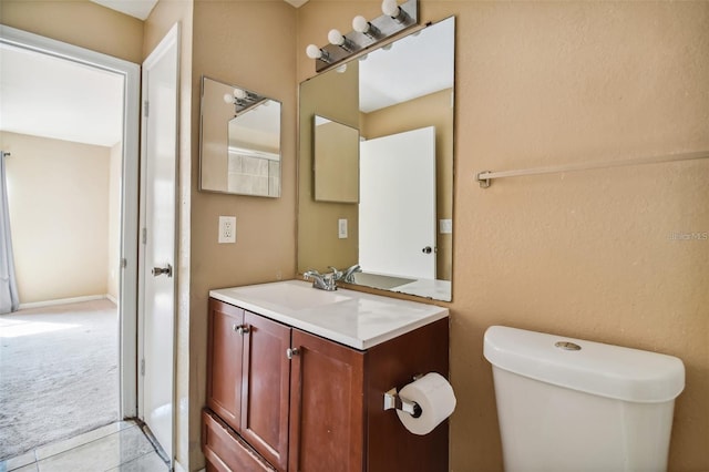 half bathroom with tile patterned floors, toilet, and vanity