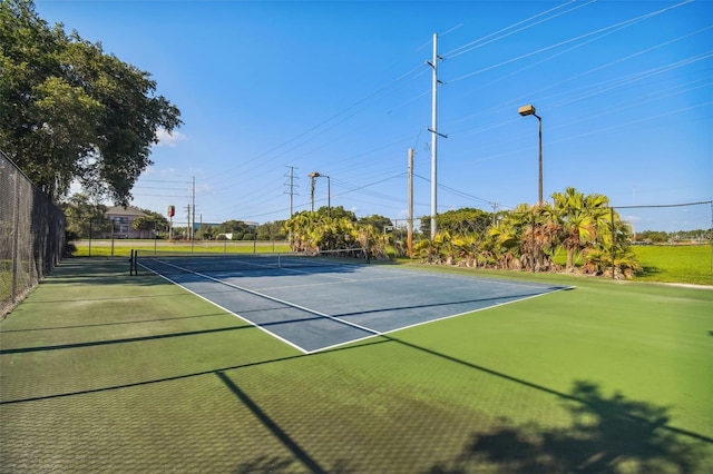 view of tennis court featuring fence