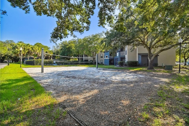 view of home's community with a lawn and volleyball court