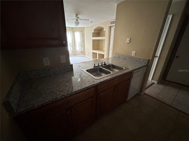 kitchen featuring built in features, white dishwasher, light tile patterned flooring, a ceiling fan, and a sink