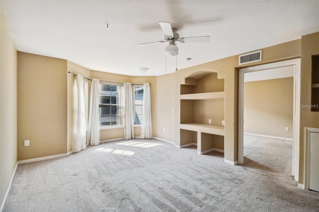 empty room featuring a ceiling fan, carpet flooring, baseboards, and visible vents