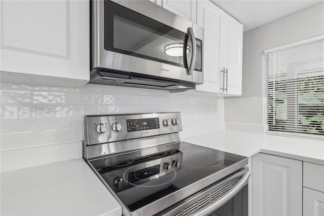 kitchen featuring white cabinets, decorative backsplash, and appliances with stainless steel finishes