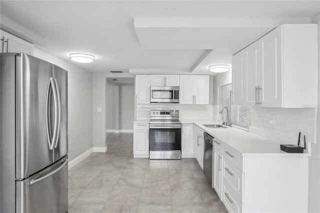 kitchen featuring decorative backsplash, stainless steel appliances, white cabinets, and sink