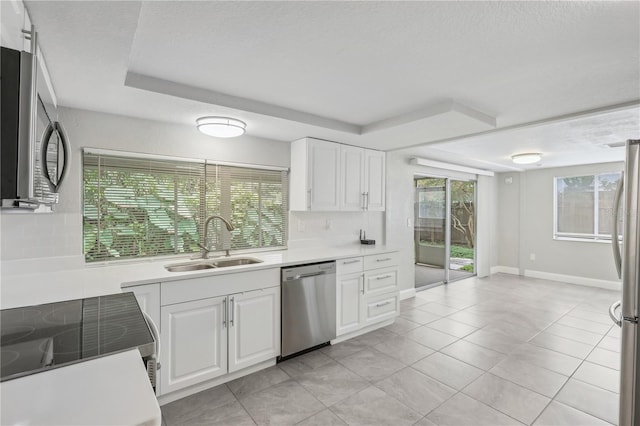 kitchen with white cabinets, light tile patterned flooring, sink, and appliances with stainless steel finishes