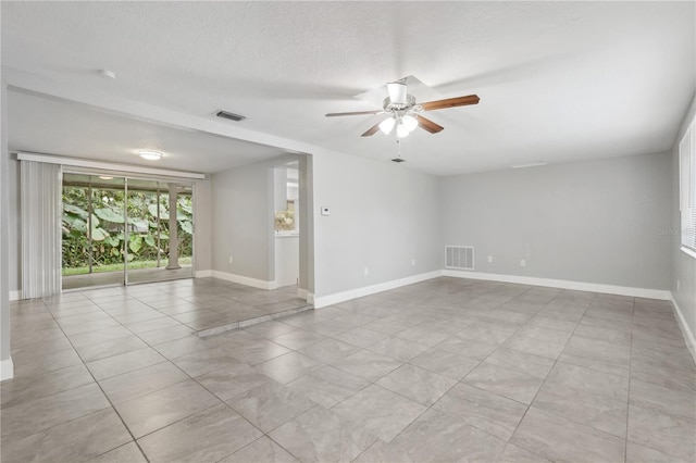 tiled empty room featuring ceiling fan