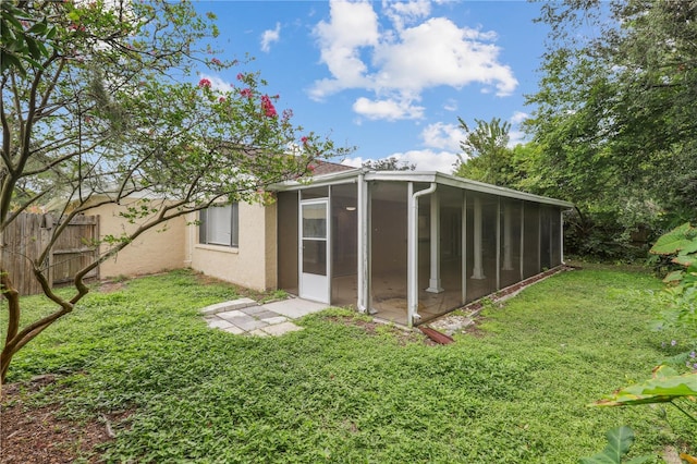 view of outdoor structure with a sunroom and a yard