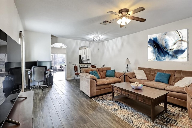 living room featuring ceiling fan and dark wood-type flooring