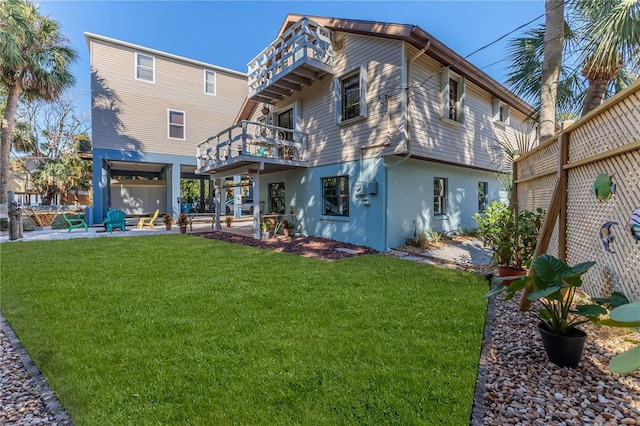 rear view of property with a yard, a balcony, and a patio