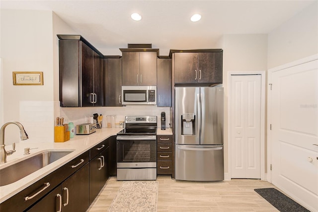 kitchen featuring light hardwood / wood-style floors, sink, appliances with stainless steel finishes, and dark brown cabinets