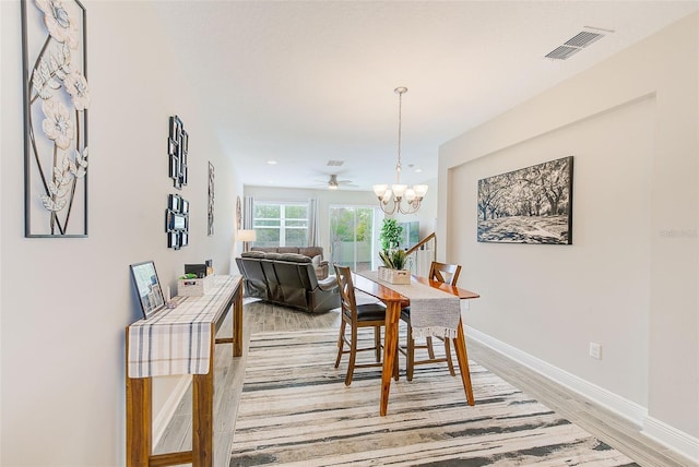 dining space with hardwood / wood-style flooring and a chandelier