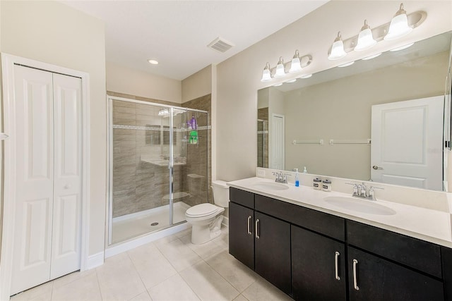 bathroom featuring a shower with shower door, toilet, vanity, and tile patterned flooring