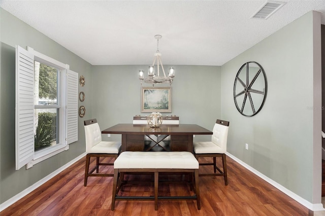 dining room featuring dark hardwood / wood-style flooring and an inviting chandelier