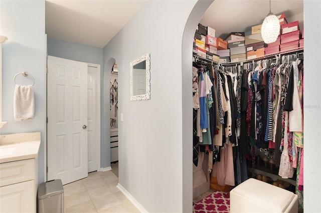 spacious closet featuring sink and light tile patterned flooring