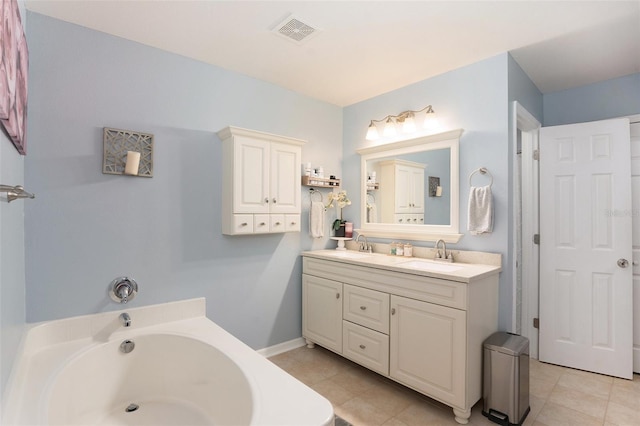 bathroom with tile patterned flooring, vanity, and a bath