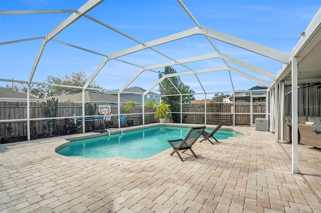 view of pool featuring glass enclosure and a patio