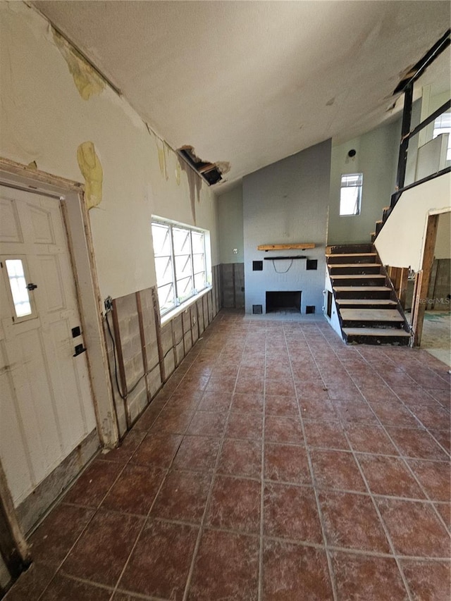 interior space with dark tile patterned floors and lofted ceiling