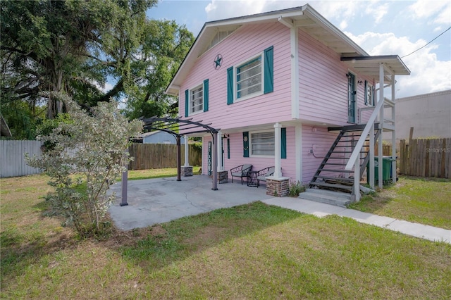 rear view of house featuring a yard, a pergola, and a patio