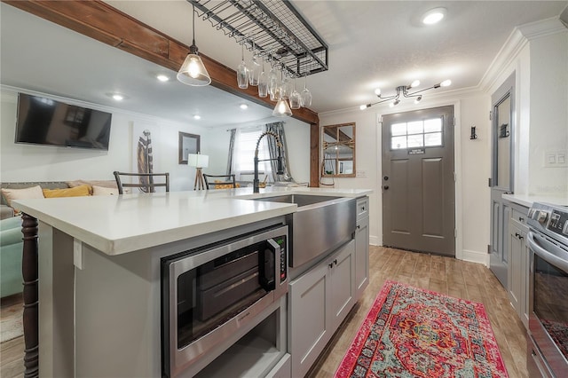 kitchen featuring a breakfast bar, appliances with stainless steel finishes, gray cabinets, and a center island