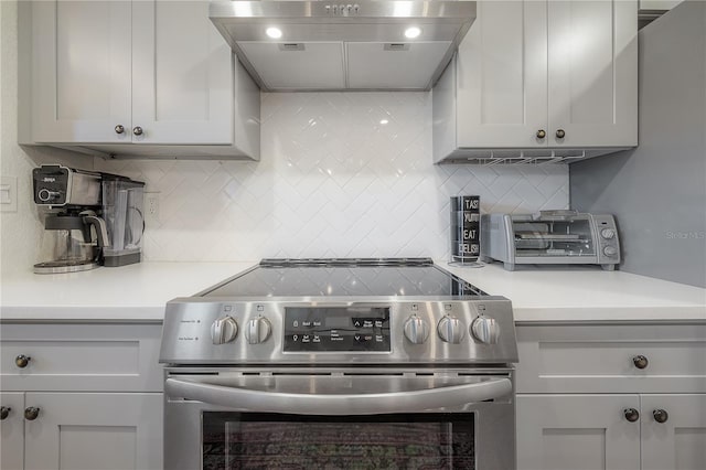 kitchen with stainless steel electric range, decorative backsplash, and range hood