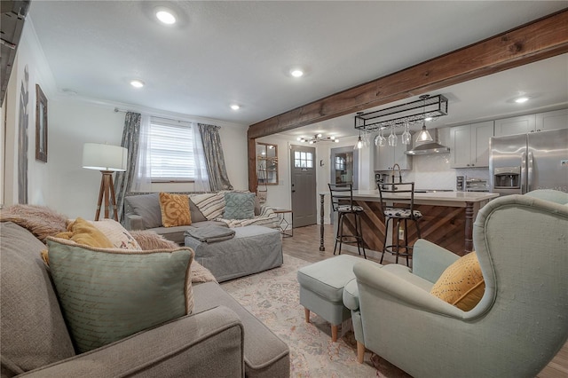 living room featuring beam ceiling, crown molding, and bar