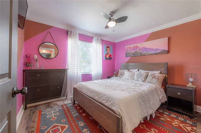 bedroom with ceiling fan, ornamental molding, and hardwood / wood-style floors