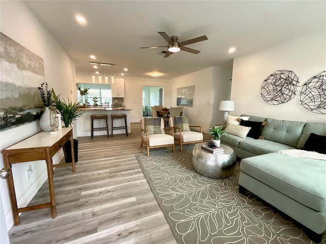 living room featuring ceiling fan and light hardwood / wood-style flooring