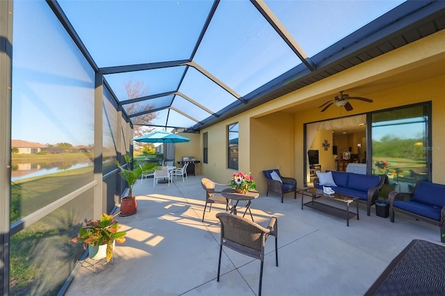 view of patio with a lanai, an outdoor living space, ceiling fan, and a water view