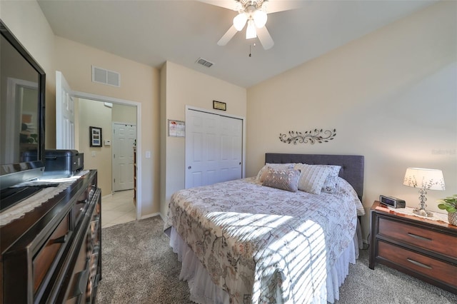 bedroom with ceiling fan, a closet, and light carpet