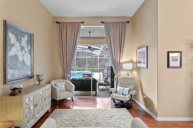 living area with ceiling fan and wood-type flooring