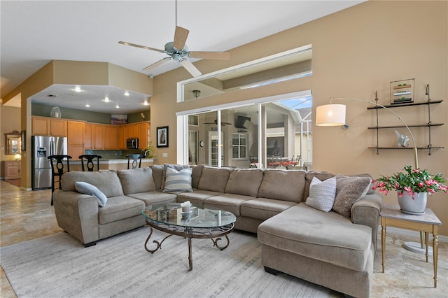 living room with a towering ceiling and ceiling fan