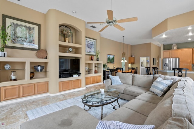 living room featuring built in shelves and ceiling fan