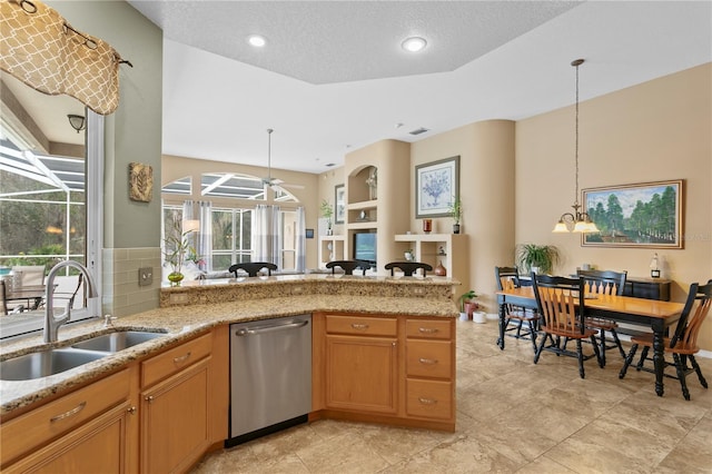 kitchen featuring dishwasher, ceiling fan with notable chandelier, sink, built in features, and decorative light fixtures