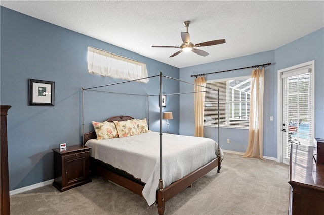 carpeted bedroom with ceiling fan and a textured ceiling