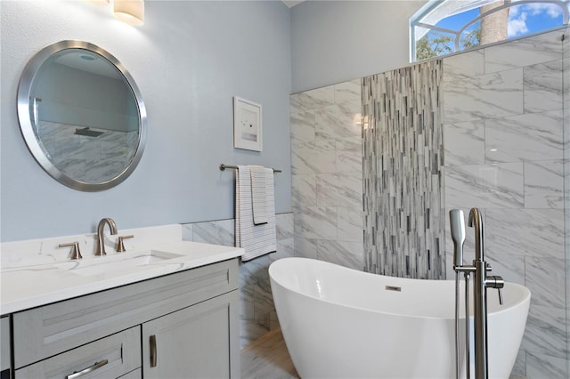 bathroom featuring a bathtub, tile walls, and vanity