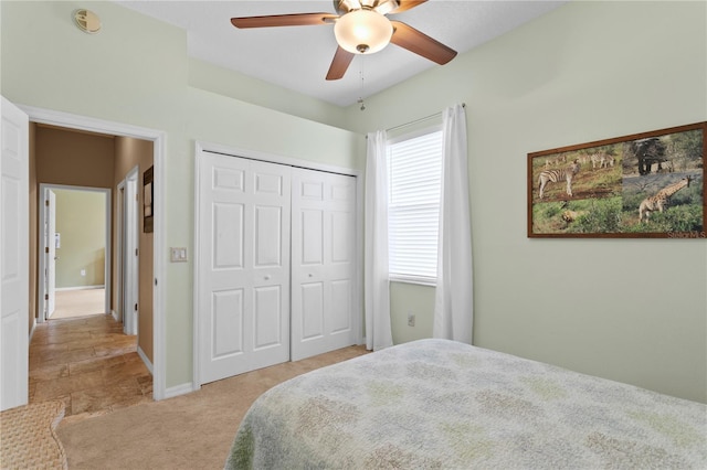 bedroom with ceiling fan, a closet, and light carpet