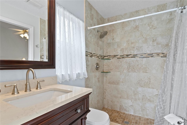 bathroom with a shower with curtain, vanity, toilet, and ceiling fan