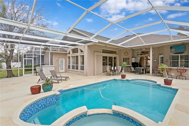 view of swimming pool featuring glass enclosure, ceiling fan, and a patio area