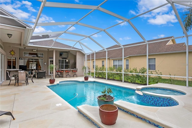 view of pool with glass enclosure, ceiling fan, a patio, and an in ground hot tub