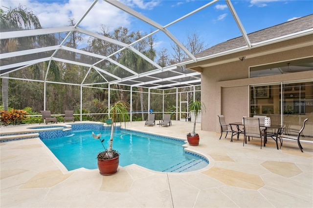 view of swimming pool featuring an in ground hot tub, glass enclosure, and a patio area