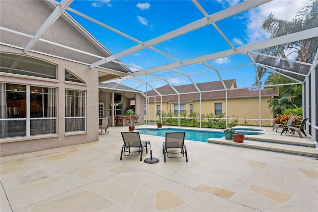 view of pool featuring a patio area, a lanai, and an in ground hot tub