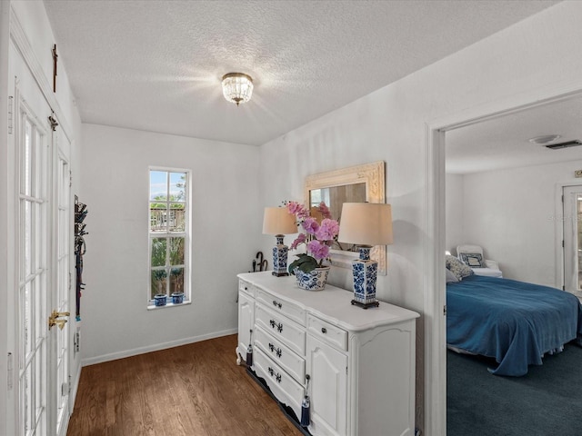 bedroom featuring dark wood-type flooring and a textured ceiling