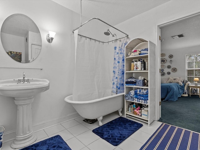 bathroom featuring a textured ceiling, tile patterned flooring, shower / bathtub combination with curtain, and sink