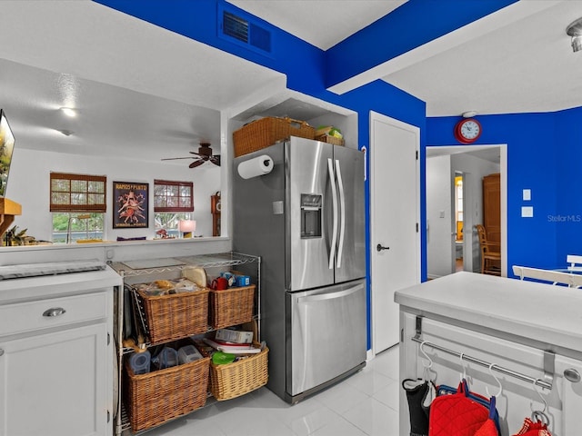 kitchen featuring ceiling fan, light tile patterned flooring, stainless steel fridge with ice dispenser, a textured ceiling, and white cabinets