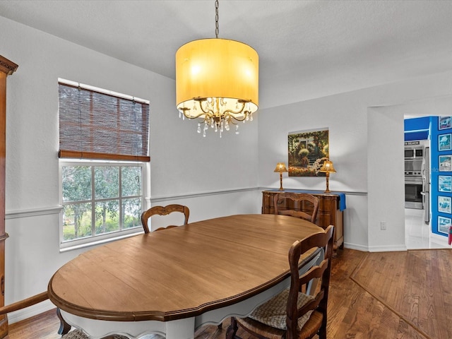 dining area featuring an inviting chandelier and wood-type flooring