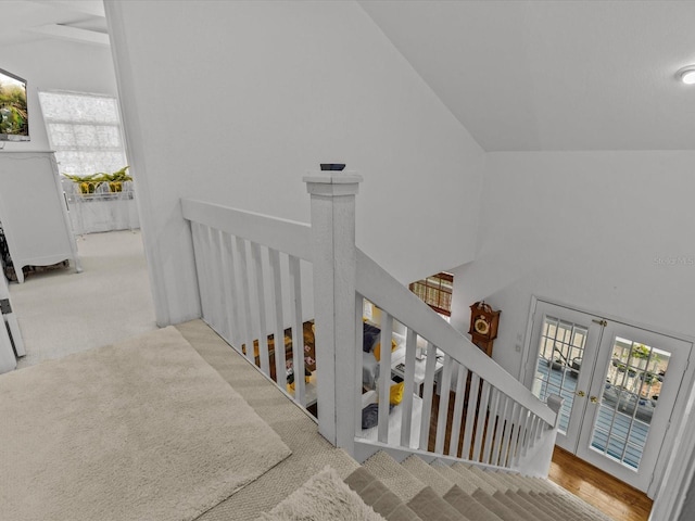 staircase with carpet, lofted ceiling, and french doors